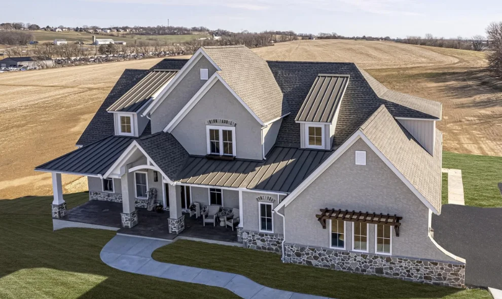 Aerial view of large custom home with dark shingle roof and stone accents, Lancaster PA roofing contractor