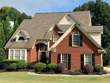 Brick two story home with shingle roof and mature landscaping, Lancaster PA roofing contractor