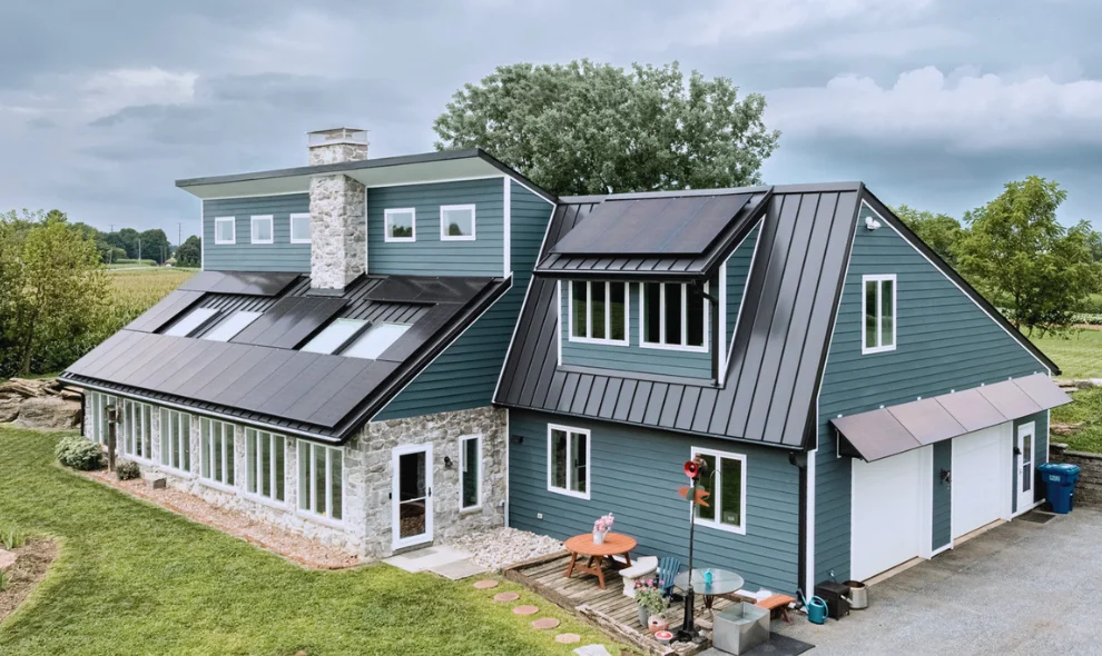 Solar-paneled farmhouse with stone chimney, deck, and patio furniture, Lancaster PA solar panel installation