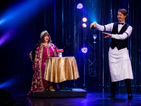 Magician performing floating glass illusion with volunteer at Magic and Wonder Dinner Theater in Lancaster PA