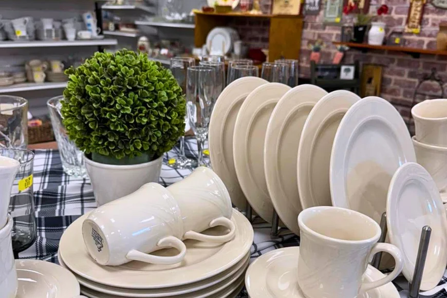 Secondhand dishware, mugs, and glassware displayed for sale at Mount Joy Gift and Thrift
