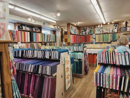 The Old Country Store interior with fabric shelves and shopper browsing, Intercourse PA quilt shop