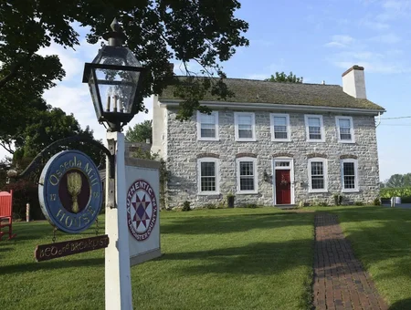 Stone farmhouse exterior with sign at Osceola Mill House Bed and Breakfast near Intercourse PA