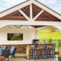 Custom outdoor pavilion with stone fireplace, TV, and bar seating built in Lancaster County PA