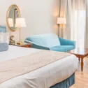 Guest room with blue upholstered headboard and sitting area at Fulton Steamboat Inn in Paradise PA