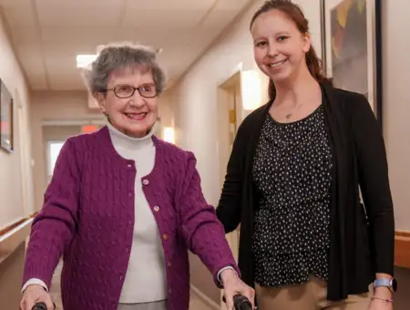 United Zion personal care staff assisting resident walking with cane in Lancaster PA hallway
