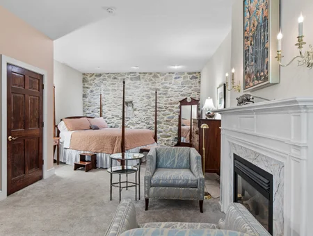 Bedroom with stone fireplace and four poster bed at Pheasant Run Farm Bed and Breakfast in Lancaster PA
