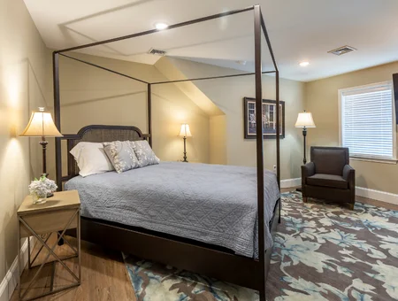Bedroom with canopy bed and armchair at The Queen Place near Kitchen Kettle Village in Lancaster PA