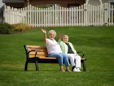 United Zion retirement living residents waving from bench on lawn in Lancaster PA