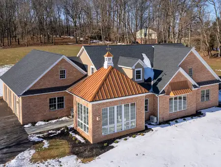 Aerial view of brick home with multiple roof gables by Duracraft Metal Roofing in Lancaster PA