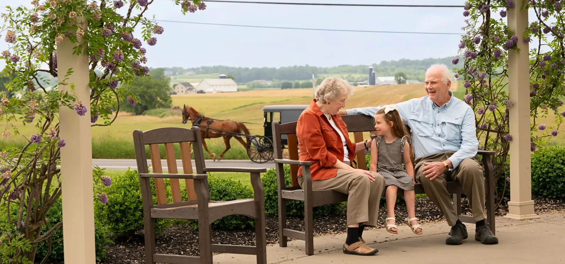 United Zion senior residents with grandchild on porch bench with Amish buggy passing in Lancaster PA