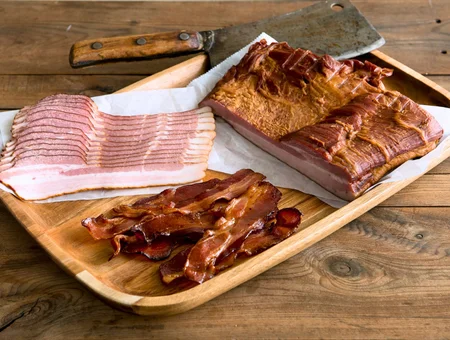 Stoltzfus Meats and Deli bacon and pork belly sliced on wood cutting board, Pennsylvania Dutch smoked meats
