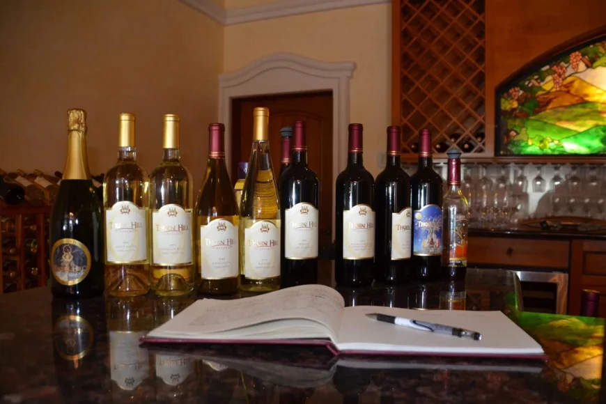 Thorn Hill Vineyards wine bottle lineup with guest book on tasting room table