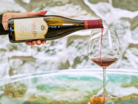 Pouring red wine from Thorn Hill Vineyards bottle into glass