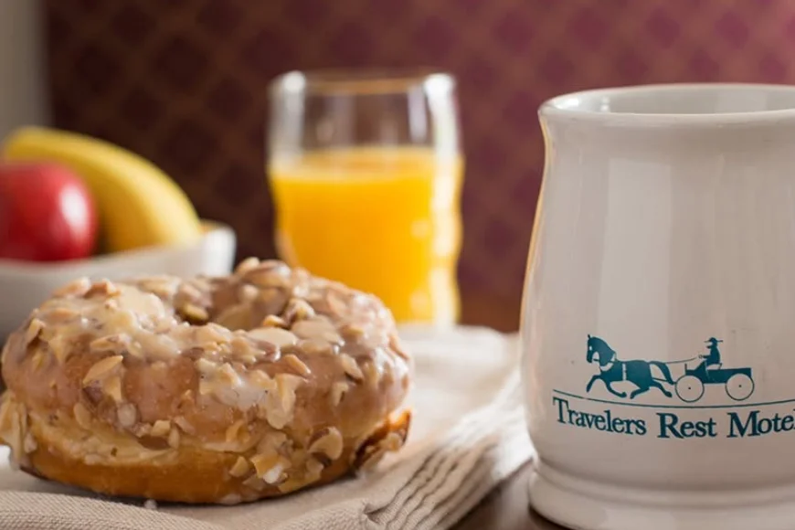 Almond donut with orange juice and branded mug at Travelers Rest Motel in Lancaster PA