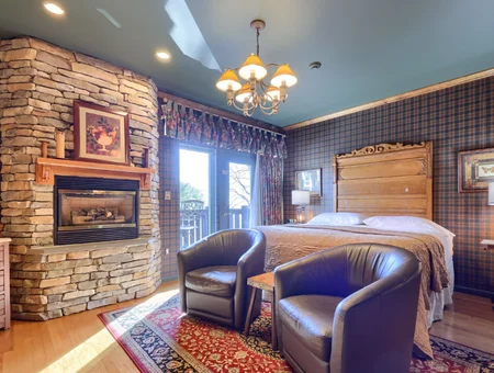 Twin Pine Manor guest room with stone fireplace, king bed, and plaid decor, Lancaster County bed and breakfast