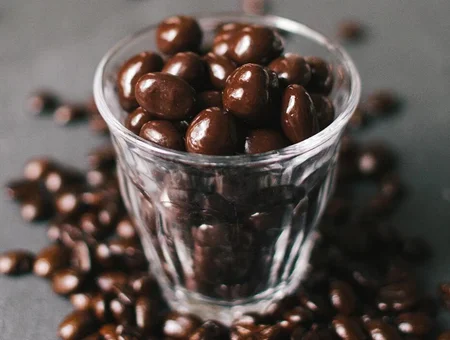 Chocolate covered almonds in glass with more scattered around, Wilbur Chocolate Pennsylvania