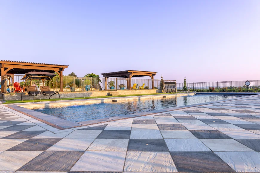 Patterned stone patio and pool with pergolas from Willow Gates Home & Landscape in Lancaster PA