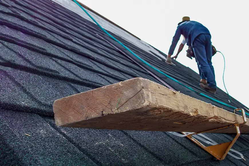Worker installing shingles on steep slope roof by Detwiler Roofing Lancaster PA