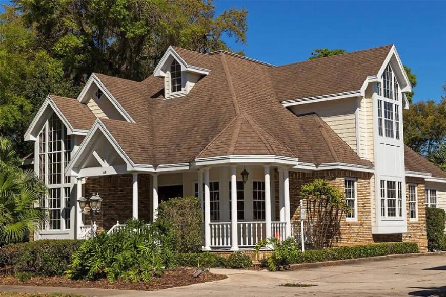 Brick home with brown shingle roof and wraparound porch by Indian Run Roofing Lancaster PA
