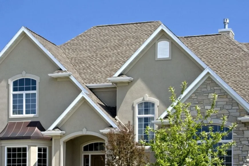 Stucco and stone home with peaked shingle roof by Indian Run Roofing Lancaster PA