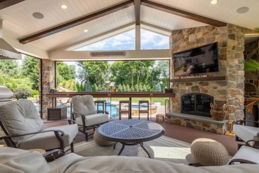 Covered outdoor living room with stone fireplace by Smucker Brothers Construction Lancaster PA